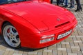 Fore part of the red sports car Porsche 944 at the cityÃ¢â¬â¢s Retro Car Show